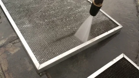 A man using high pressure water jet cleaning filter Stock Footage 76048214