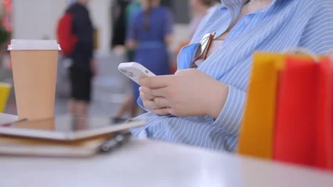 Man is using his cell phone while sitting at a table with a laptop Stock Footage 310224555