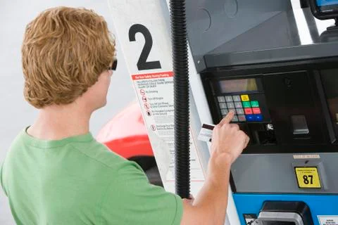 Man Using His Debit Card To Pay For Gasoline At Pump Stock Photos