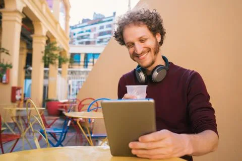 Man using his digital tablet while drinking beer. Stock Photos