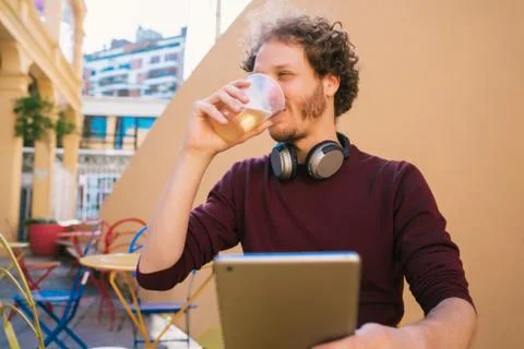 Man using his digital tablet while drinking beer. Stock Photos