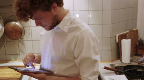 A man is using his iPad in the the kitchen Stock Footage 40356904