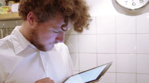 A man is using his iPad in the the kitchen Stock Footage 40357869