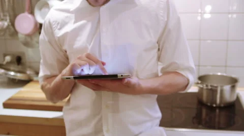 A man is using his iPad in the the kitchen Stock Footage 40358352