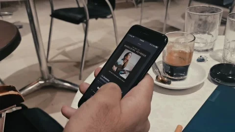 Man using his iphone to switch between differnet song on apple music in a cafe. Stock Footage 140610413