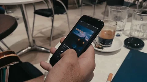Man using his iphone to switch between differnet song on apple music in a cafe. Stock Footage 140610424
