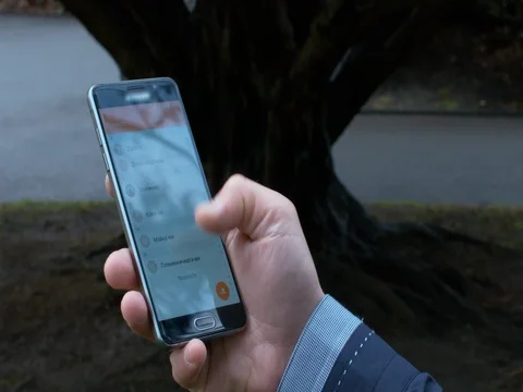 Man Using His Mobile In the Park, Searching Contacts Stock Footage