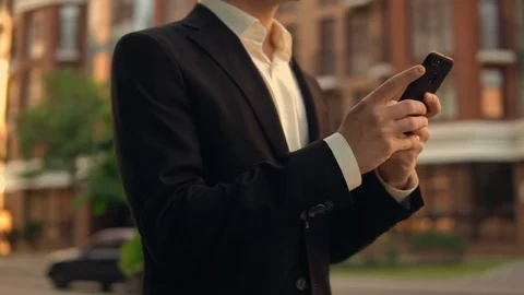 Man using his mobile phone walking along the avenue Stock Footage 92030356