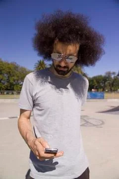 A man using his mobile phone in a skatepark Stock Photos