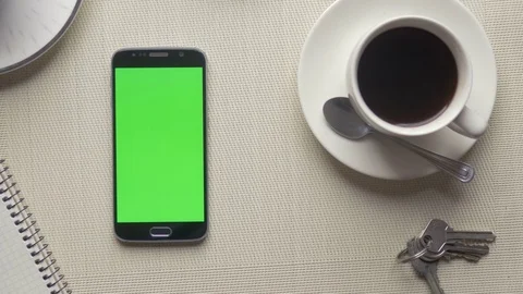 Man using his phone with green screen next to a cup of coffee Stock Footage 75457991
