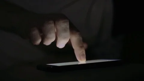 Man using his smart phone in bed at night close up Video stock 73554786