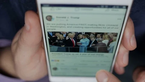 Man using his smartphone with to scroll a  Official facebook profile of presi Stock Footage 85384791