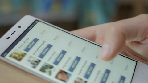 Man using his smartphone with to scroll a Facebook account feed, scrolling ne 스톡 동영상 89351954