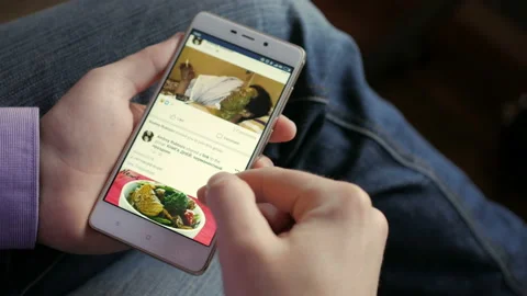 Man using his smartphone with to scroll a Facebook account feed, scrolling ne Stock Footage 96238441