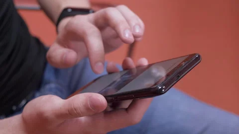 Man using his smartphone with to scroll a scrolling news, tapping on screen Stock Footage 141662682