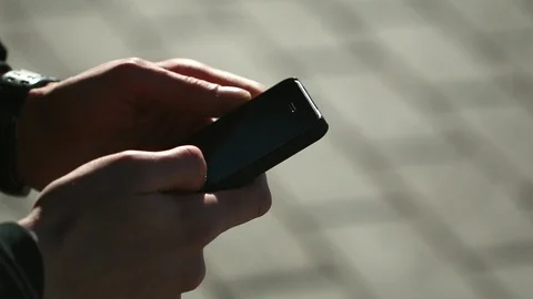 Man is using his smartphone at the street. Close up of male hands. Stock Footage 88505738