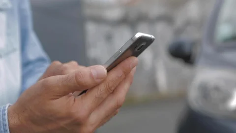 Man using his smartphone in street with blurred background. Scrolling Social Видео 110772143