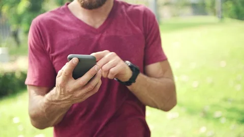 Man using his sport smart phone in park. Video stock 92342251