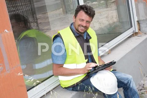 Man using his tablet computer in a construction site Stock Photos