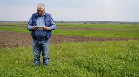 A man using his tablet on the field Stock Footage 63370879