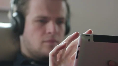 Man using his tablet to search for music Stock Footage 40667965