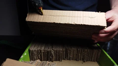 Man using hot glue gun to glue cardboard pieces Video stock 170433948