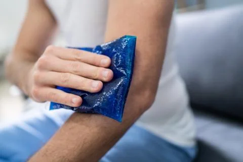 Man Using Ice Gel Pack On Arm Stock-Fotos