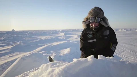 Man Using Ice Pick to Mine Ice for water in the Arctic Stock Footage 74779537
