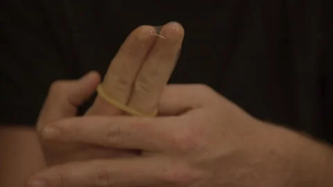 Man using index and middle finger to demonstrate condom use Stock Footage 193994738