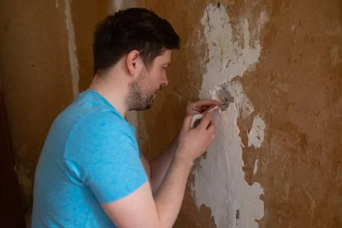 Man is using an insulating tape to the bare electric wires. Stock Photos