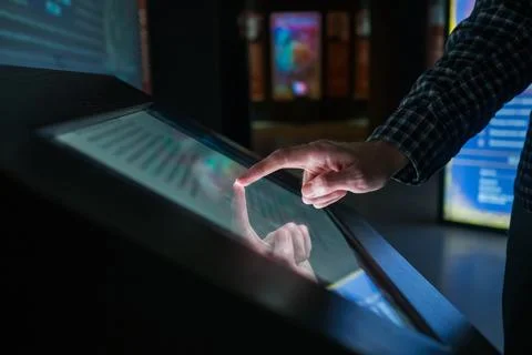 Man using interactive touchscreen display at modern museum or exhibition Stock Photos