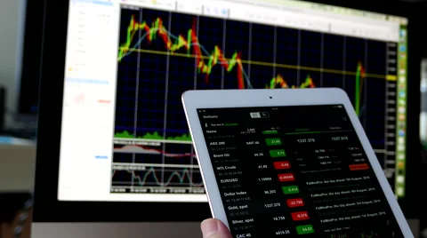 Man using ipad to check exchange rate with exchange rate chart on iMac Stock Footage 66372481