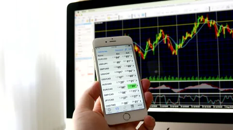 Man using ipad to check exchange rate with exchange rate chart on iMac Stock Footage 66780948