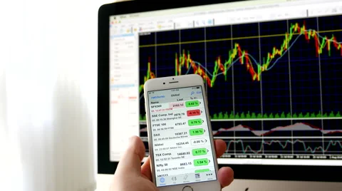 Man using ipad to check exchange rate with exchange rate chart on iMac Stock Footage 66783175