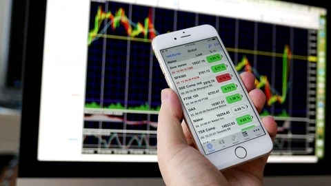 Man using ipad to check stock market price with exchange rate chart on iMac Stock Footage 72233248