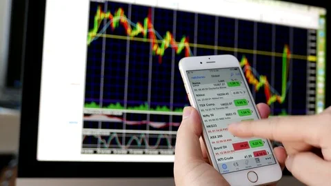 Man using ipad to check stock market price with exchange rate chart on iMac Stock Footage 72251785