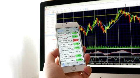 Man using ipad to check stock market price with exchange rate chart on iMac Stock Footage 72262420