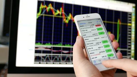 Man using ipad to check stock market price with exchange rate chart on iMac Stock Footage 114052205