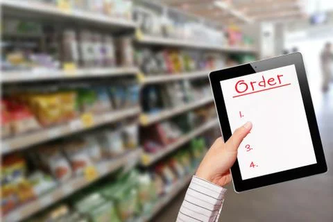 Man using ipad while shopping in supermarket Stock Photos