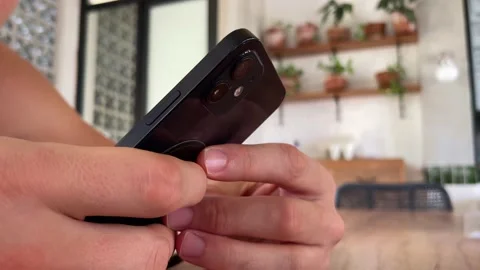 Man using iPhone 12 smartphone pressing finger, reading social media internet, t 動画素材 201734520