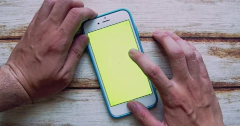 Man using iPhone with Green Screen chroma key on wooden shabby chic table Video stock 161766866