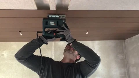 Man using a jigsaw to cut shiplap on the ceiling 스톡 동영상 151215043