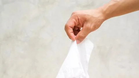 Man using a Kleenex on gray background. Stock Photos