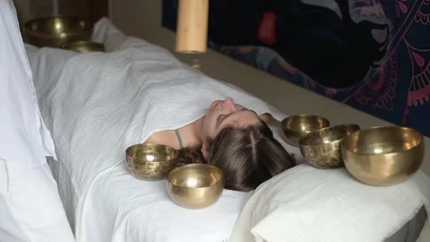Man using a Koshi chime during sound healing therapy with tibetan singing bowls Stock Footage 213890125