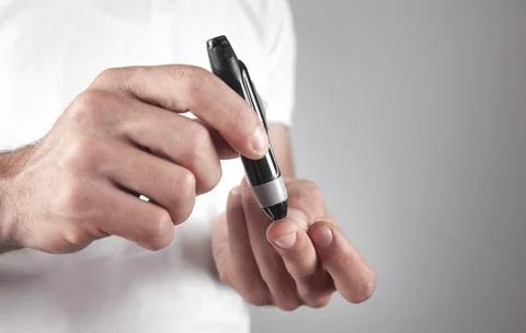 Man using lancet on finger. Checking blood sugar level Foto stock