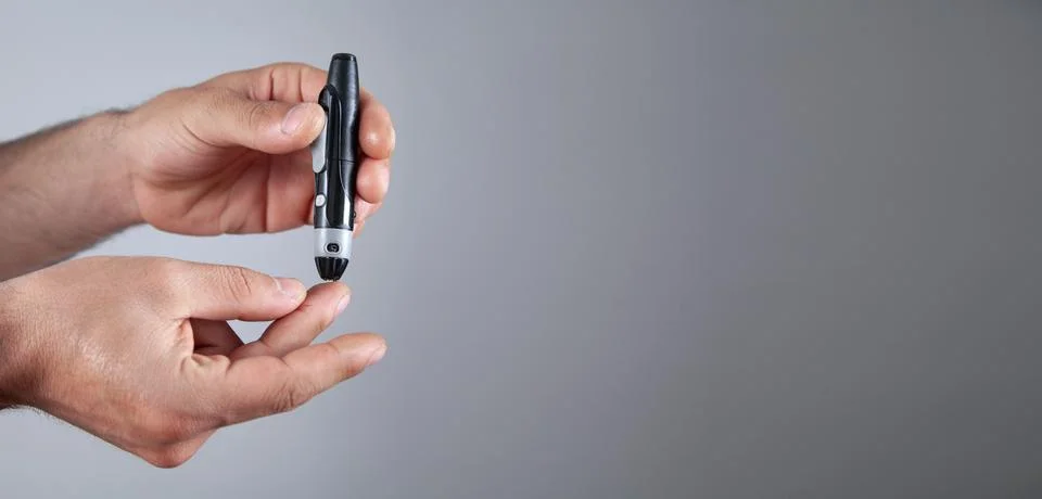 Man using lancet on finger. Checking blood sugar level Stock Photos
