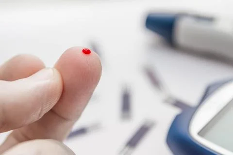Man using lancet pen to checking blood sugar level by blood glucose meter. Stock Photos