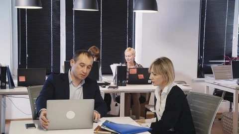 Man using laptop and discussing new project with woman Stock Footage 113631841