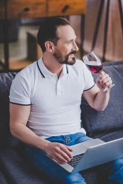 Man using laptop and drinkingwine Stock Photos