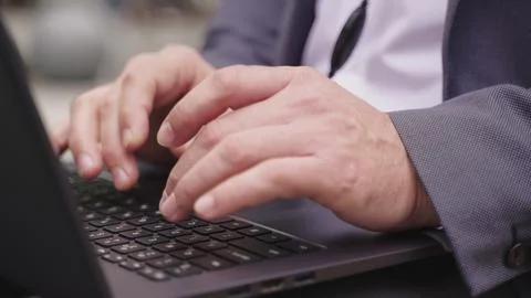 Man using laptop and headset while sitting in the city. Slow motion Stock Photos